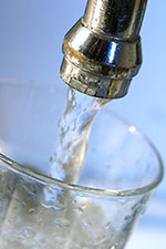 Water flowing into glass from faucet