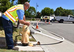 A water operator opens a hydrant to flush a drinking water main.