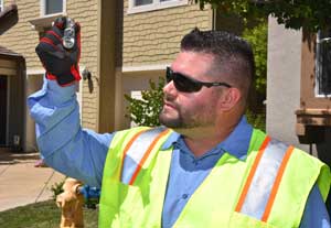 A water operator holds up a vial of water to check turbidity in sunlight.