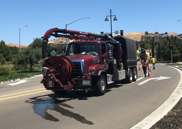 The hydrovac truck on the street in a neighborhood.