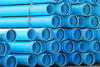 Stock image of blue water pipes stacked together.