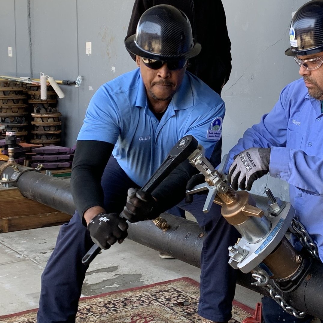 Cliff McClure drills a hole into a pipeline during a pipe-tapping competition