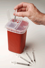 photo of hand placing syringe in a red sharps disposal container