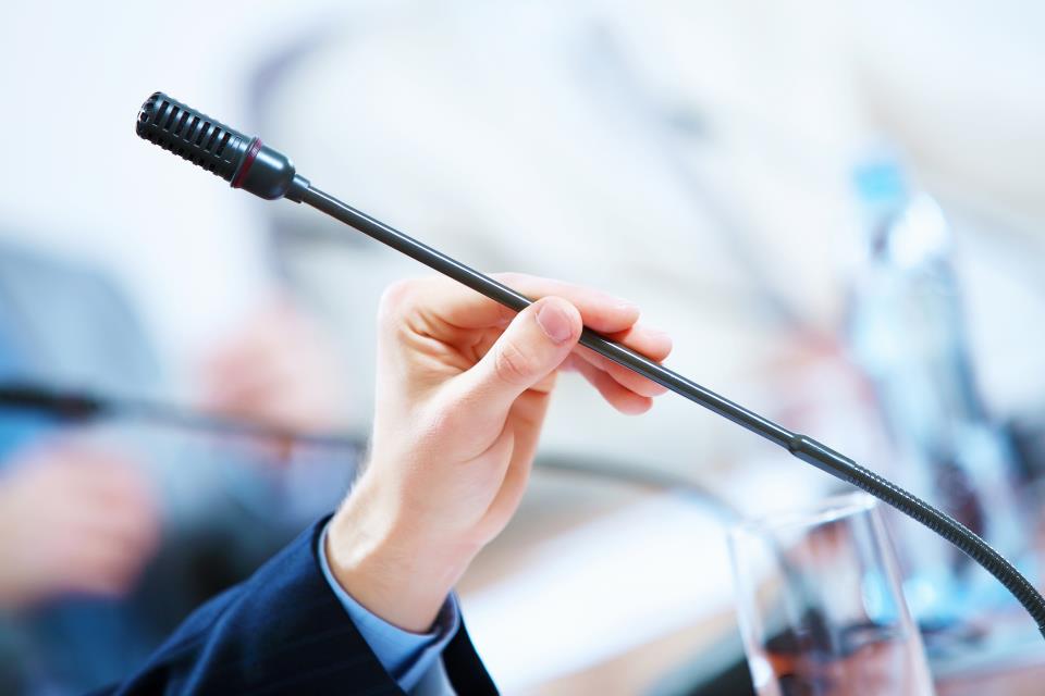 Speaker with Microphone. Hand holding a microphone 